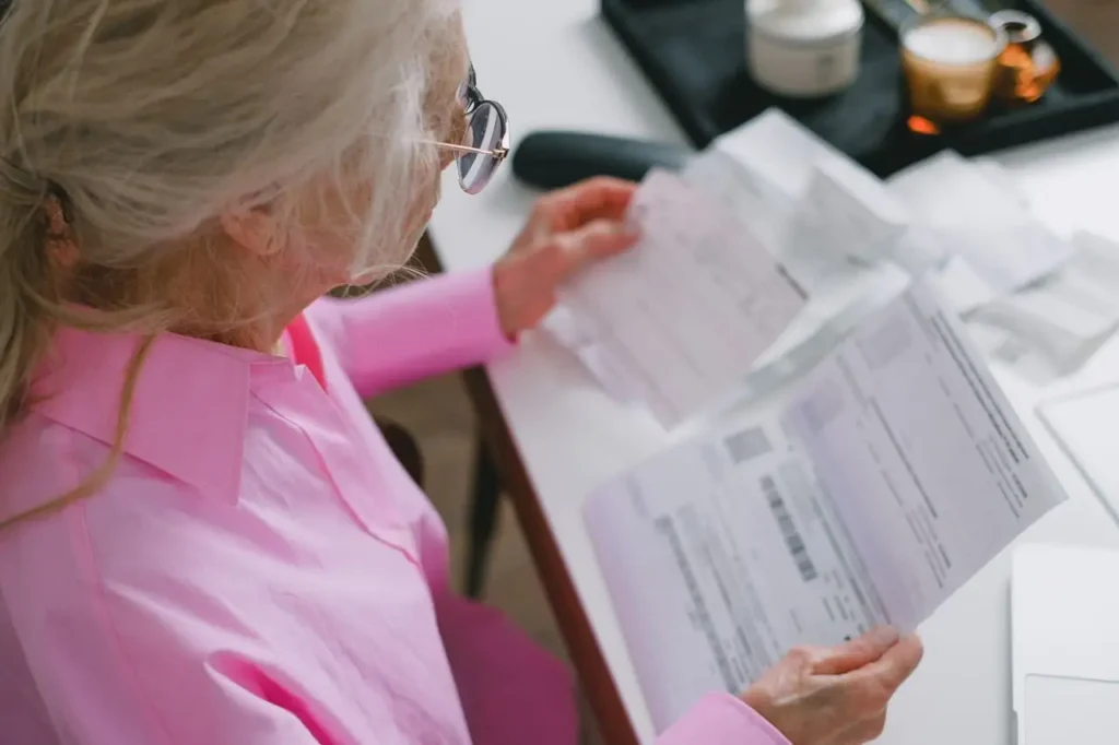 Mujer mayor leyendo documentos en casa