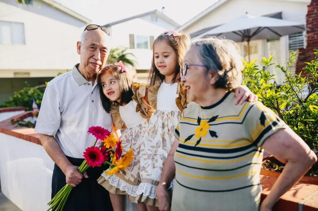 Abuelos con sus nietos en un jardín con flores