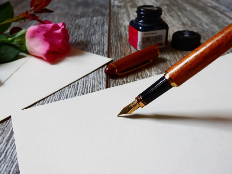 Abogado de herencias en Menorca: pluma estilográfica sobre papel junto a una rosa