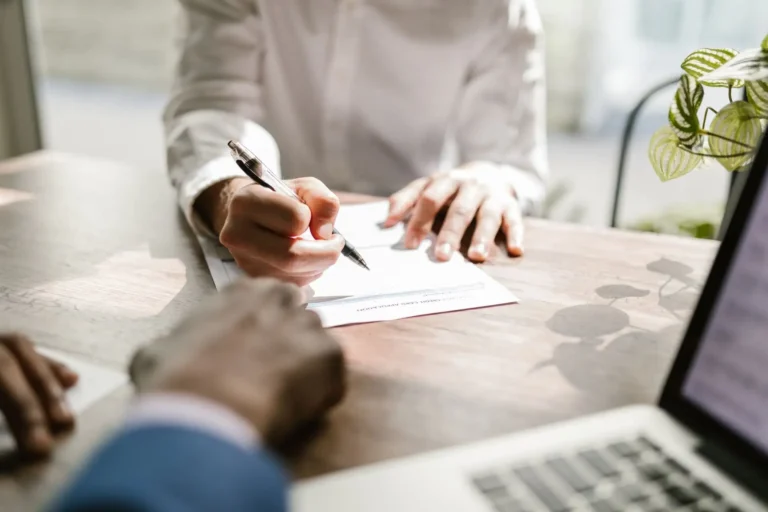 Personas firmando un documento en una mesa