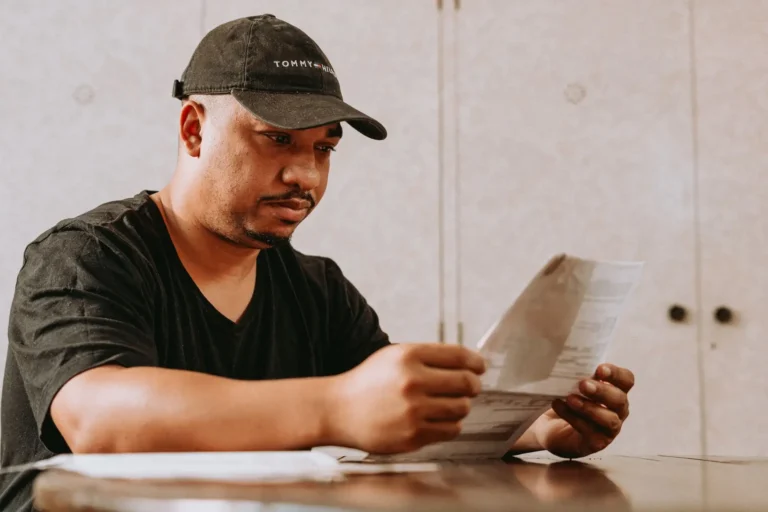 Hombre leyendo con atención unos papeles en una mesa