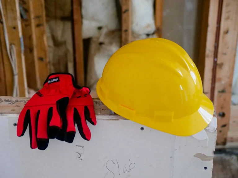 Accidente de trabajo: casco amarillo y guantes rojos en una obra