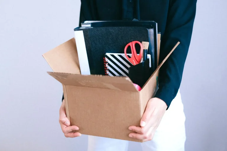 Despido improcedente: persona llevando una caja con sus cosas de la oficina