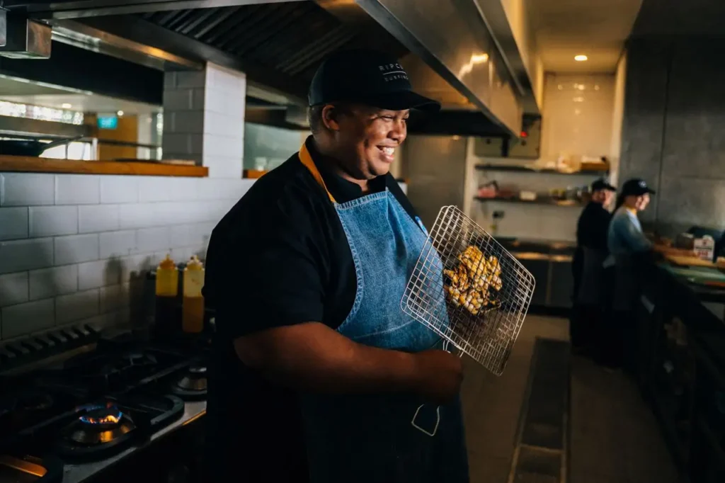 Cocinero sonriendo en la cocina de un restaurante