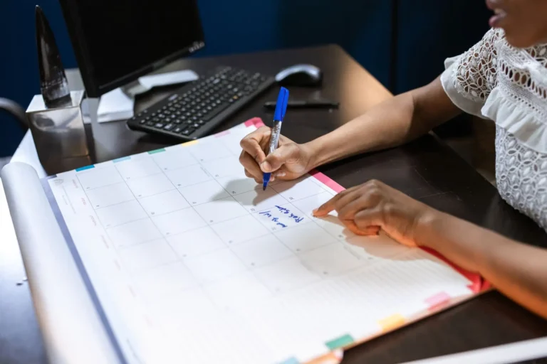 Persona anotando en una agenda de escritorio